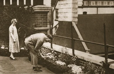 Una pareja cuidando su jardín privado en la azotea de un edificio en Tudor Street, de Maravilloso Londres, publicado 1926-27